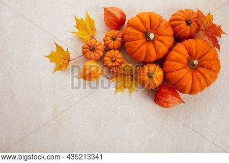 Autumn Framework From Pumpkins, Berries And Leaves On A Travertine Background. Concept Of Thanksgivi