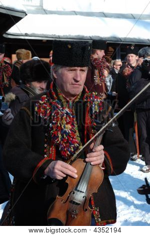 Gutsul (Ucraniano Highlander en montañas de los Cárpatos) con violín están preparando para jugar Navidad C