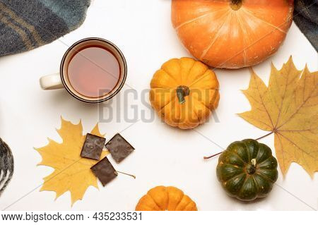 Top View Of Autumn Table With Fallen Colorful Leaves, Pumpkins, Warm Clothes And Chocolate Slices