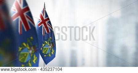 Small Flags Of Pitcairn Islands On A Blurry Background Of The City