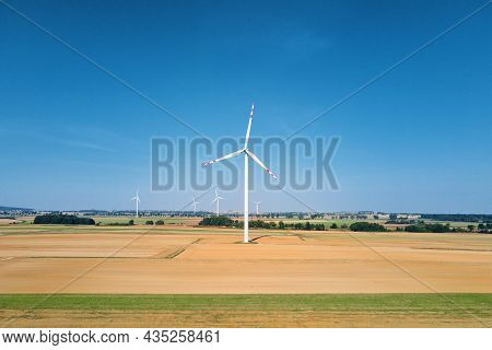 Windmill Among Agricultural Fields. Wind Turbine Generator At Summer Day. Wind Energy Concept. Suist