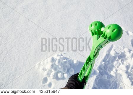 A Children Toy Is A Tool For Modeling Snowballs From Snow. Green Color Plastic Device. Winter Outdoo