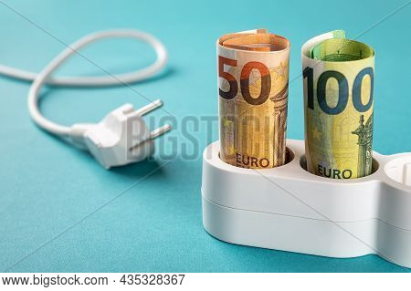 Fifty And One Hundred Euro Banknotes Plugged Into A White Power Strip Over Blue Bacground. Increasin