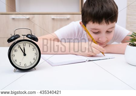 A Concentrated Boy Writing In A Textbook, Exercisebook, A Schoolboy Doing His Homework At Home, An A