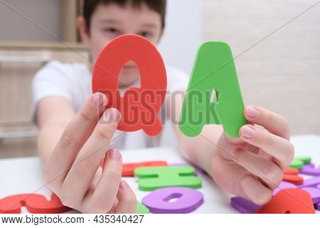 A Boy Holding Colorful Letters Q And A, Questions And Answers Concept, Solvation Kids Problems