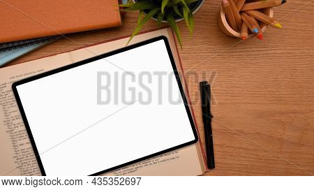 Top View Of Study Table With Tablet Computer Blank Screen Mockup On Wooden Table