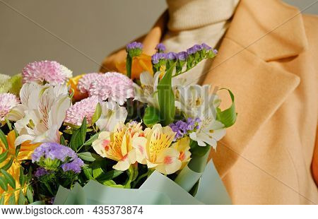 A Woman In A Beige Coat Holds A Beautiful Autumn Bouquet In Her Hands. Depersonalization Concept. Cl