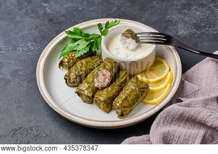 Traditional Dolma With Parsley And Lemon In Light Plate With Napkin On Dark Table, On Black Fork Pri