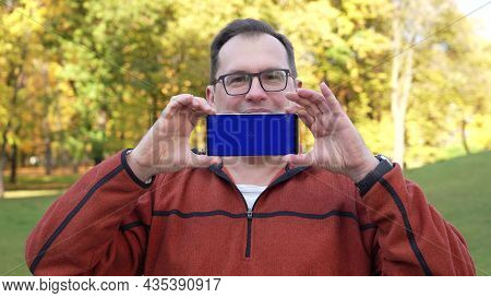 Man Holdingsmartphone With Blue Screen And Chroma Key.