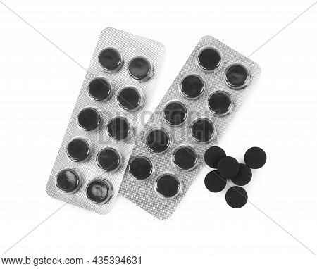 Activated Charcoal Pills On White Background, Top View. Potent Sorbent