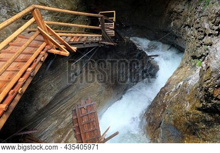 Wooden Walkpath As Bridge Over Cascading Waterfall