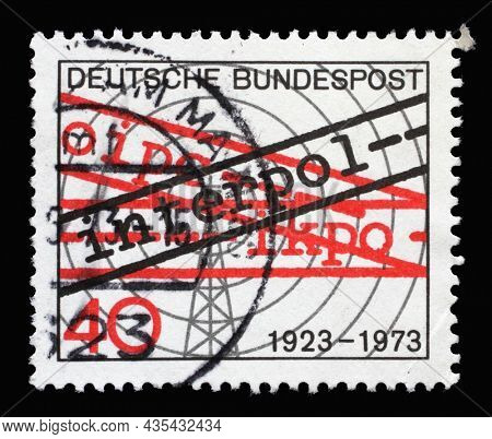 ZAGREB, CROATIA - JUNE 27, 2014: A stamp printed in Germany showing a transmission tower with radio waves and Interpol, 50th anniversary of International Criminal Police Organization, circa 1973