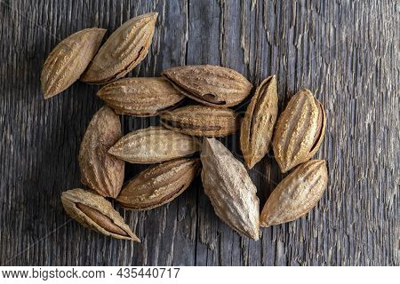 Inshell Almonds On A Background Of Rough Wood Texture. Selective Focus.