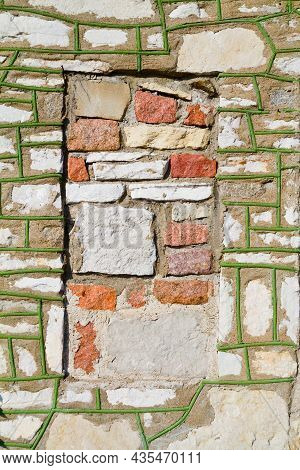 Brick Side Of A Building With Moss Growing In The Cracks With A Red Square Where Part Of The Brick H