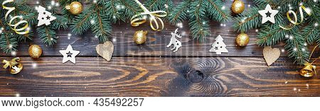 Christmas Background With Wooden Ornaments, Golden Balls And Bells On A Wooden Table. New Year Card.