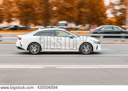 Kia K5 Is Driving Along The Street With An Autumn Urban Background. Kia Optima Dl3 On The City Road.