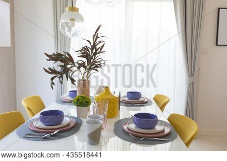 Yellow Chair And Table With Pink Pastel Plate Setting On Dinning Table.