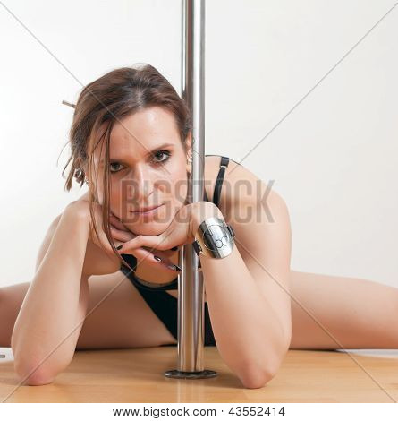 Die junge Frau in der Nähe von einer Stange