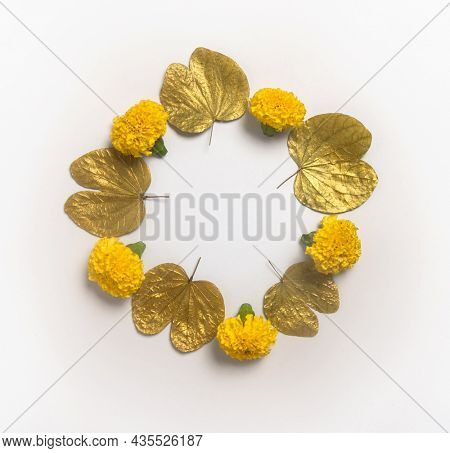 Dussehra greetings background unit with clear space for message.  Golden Apta leaves and marigold flowers arranged in a circular shape with empty space for logo or text.