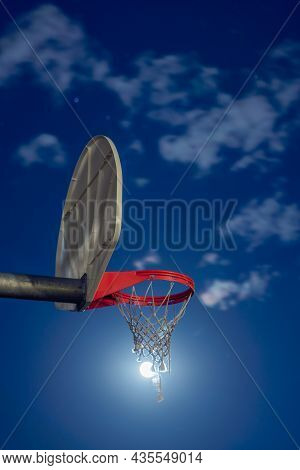 A Closeup Creative Sports Background Photograph Of A Basketball Hoop In A Park At Night With The Moo