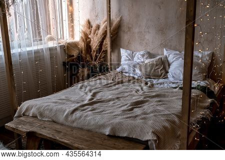 Home Interior With Four Poster Bed. There Are Many White And Beige Pillows And Bedspreads On The Bed