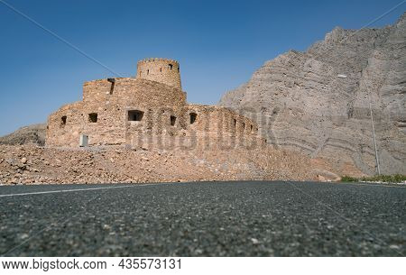 Stone Walls Of Small Medieval Arabian Fort Under Tall Mountain Cliffs. Fortress In Bukha, Musandam P