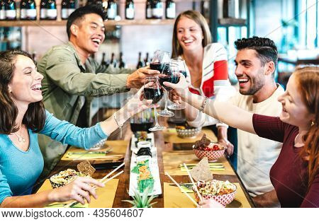 Multiracial Friends Toasting Red Wine At Sushi Restaurant - Food And Beverage Lifestyle Concept With