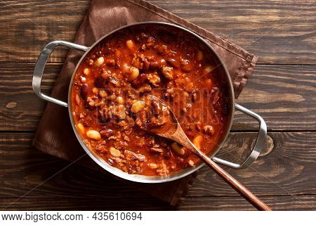 Stewed Beans With Ground Beef, Jalapeno Pepper And Bacon In Cooking Pan Over Wooden Background. Top 