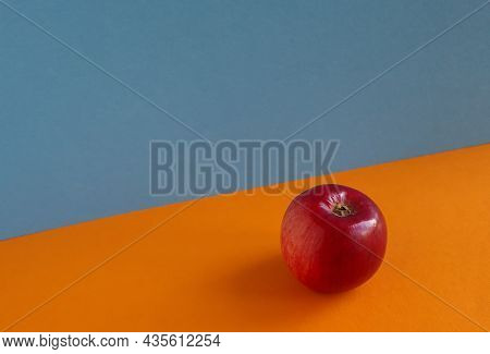 Red, Ripe Apple On Orange And Blue Background