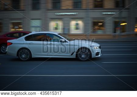 White Bmw 5 Series G30 Driving In Night City Streets. Moscow, Russia - October 2021