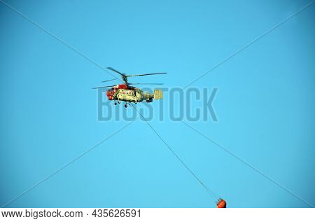 Russian KA-32 helicopter draws water from the sea to extinguish a forest fire. 30 July, 2021. Marmaris,Turkey