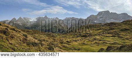 Panorama Picture In The Swiss Alps. Hiking Through Deep Valleys To High Mountains. View Of The Mount