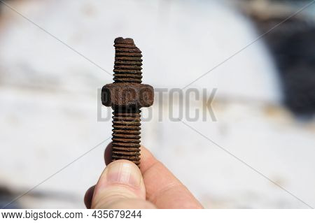 Old Rusty Bolt, Iron Rod With Screw Threads, In Hand. Rusted Mechanical Components. Holding Threaded