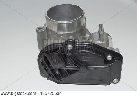 View From The Side Of The Black Plastic Cover On The Car Throttle Valve Which Lies On A White Surfac