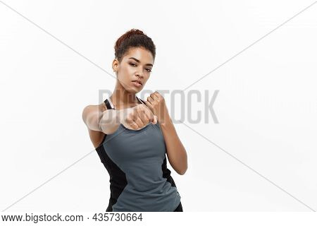 Healthy And Fitness Concept - Portrait Of African American Woman Punching In Air With Confident Face