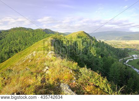 The Top Of The Mountains In The Morning Light Under A Blue Cloudy Sky In The Altai Mountains. Siberi