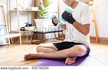 Asian Caucasian Man Hold Dumbbell In Home Training Exercise Bodyweight Trainer Indoors Workout Sport