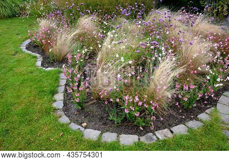 Perennial Beds With Ornamental Grasses And Pink Perennials. The Edge Of The Flowerbed Into Arches An