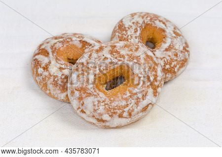 Spice Cookies In The Form Of Rings Glazed With Icing Sugar On The White Fabric Napkin, Close-up In S