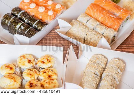 Rolls In A Cardboard Box With Salmon, Nuri Seaweed, Rice, Sesame Seeds. Home Delivery. Hot Rolls.