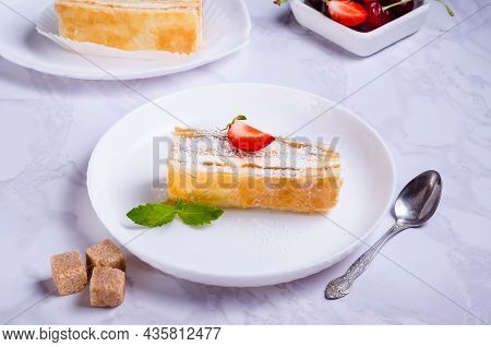 Puff Pastry Cake With Cream On A White Plate
