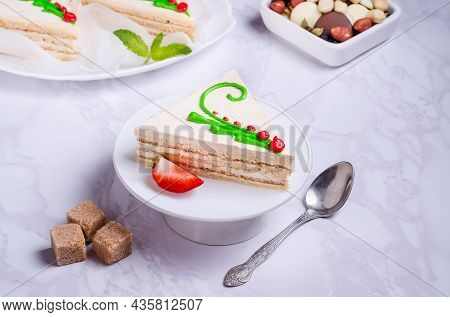 Sponge Cake With Cream And Icing On A White Plate On A Marble Background