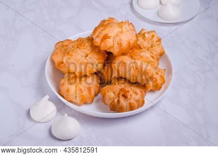 Dessert Profiteroles With Cream On A White Plate On A Marble Background