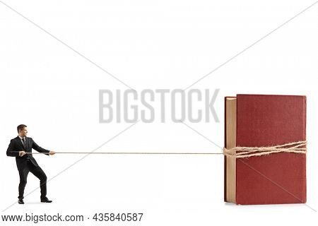 Full length profile shot of a professional man in a suit and tie pulling a book with a rope isolated on white background
