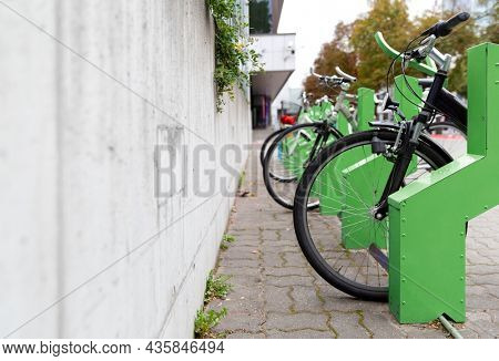 transport and sustainability concept - bicycles at electric bike charging station on city street