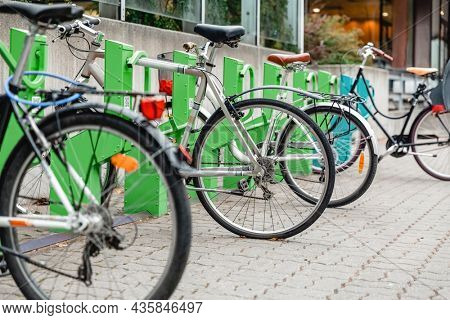 transport and sustainability concept - bicycles at electric bike charging station on city street
