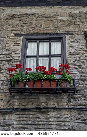 balcony with flowers, Facade of a medieval building in the center of Pamplona, ??medieval stone streets, typical and tourist alley of the city. Navarra Spain