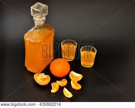 Homemade Tangerine Liqueur, A Glass Bottle And Two Glasses With Alcohol On A Black Background, Next