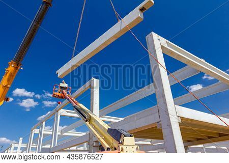 Mobile Crane Is Operating And Worker Is Assembly Concrete Joist In High Place. Height Worker Is Plac