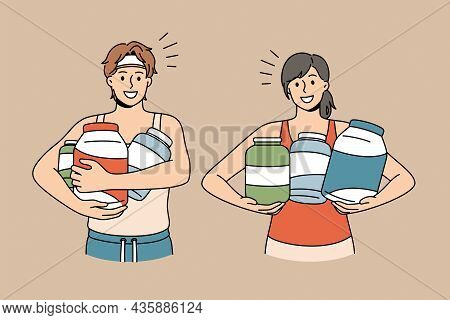 Dietary Supplement And Sport Concept. Young Smiling Couple In Sportswear Standing Holding Jars With 